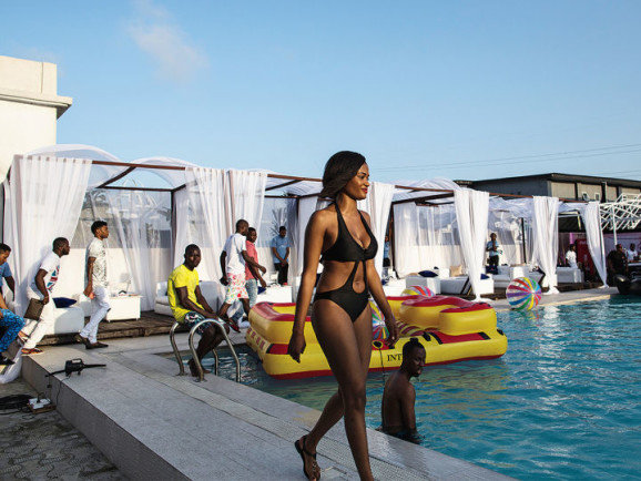 A woman walks by the pool at a party hosted by Quilox and promoted by Bizzle.